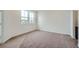 Cozy bedroom featuring plush carpet, ample natural light from a large window, and neutral decor at 702 N Bently St, Watkins, CO 80137