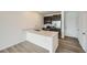 Modern kitchen featuring a breakfast bar, stainless steel appliances, and wood floors at 702 N Bently St, Watkins, CO 80137