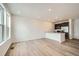 Bright living room featuring wood floors, recessed lighting, and open layout to the kitchen at 702 N Bently St, Watkins, CO 80137