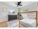 Bright bedroom featuring wood floors, a black dresser, and a stylish canopy bed at 3103 W Bellewood Dr, Englewood, CO 80110