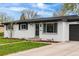 Charming single-story home with white brick exterior, well-manicured lawn and concrete driveway at 3103 W Bellewood Dr, Englewood, CO 80110