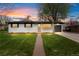 Beautiful home with a manicured front lawn, freshly painted white brick, and an attached garage at 3103 W Bellewood Dr, Englewood, CO 80110