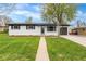 Charming home with a freshly painted exterior, manicured lawn, and attached garage at 3103 W Bellewood Dr, Englewood, CO 80110