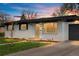 Charming home with a well-manicured lawn, freshly painted white brick, and an attached garage at 3103 W Bellewood Dr, Englewood, CO 80110