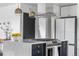 Modern kitchen island featuring a stainless steel cooktop, marble countertops and stylish cabinets at 3103 W Bellewood Dr, Englewood, CO 80110