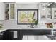 Close-up of a kitchen featuring white cabinets, stylish fixtures, ample storage, and a view to the outdoors at 3103 W Bellewood Dr, Englewood, CO 80110