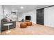 Finished basement living room with carpet, TV and sleek black sliding barn door at 3103 W Bellewood Dr, Englewood, CO 80110