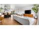 Bright and airy living room featuring wood floors, modern furniture, and seamless flow to kitchen and dining area at 3103 W Bellewood Dr, Englewood, CO 80110