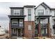 Modern townhome with gray and white siding and brick porch supports at 1342 Independence St # 6, Lakewood, CO 80215