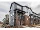 Modern townhome with gray siding, brick accents, and covered porch at 1342 Independence St # 6, Lakewood, CO 80215