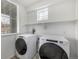 A laundry room features a window, shelving and a Whirlpool washer and dryer at 1342 Independence St # 6, Lakewood, CO 80215