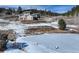 Aerial view of a home set on a vast lot with a pond, surrounded by snow-covered terrain and trees at 20101 Spring Gulch Rd, Morrison, CO 80465