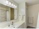 Well-lit bathroom featuring a sink with vanity, a large mirror, and an adjacent shower with tile surround at 20101 Spring Gulch Rd, Morrison, CO 80465