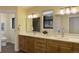 Bright bathroom featuring double sinks, quartz counters, modern lighting, and a large mirror at 20101 Spring Gulch Rd, Morrison, CO 80465