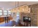 Elegant dining area with modern light fixture and stone fireplace, next to a bar area and access to the backyard at 20101 Spring Gulch Rd, Morrison, CO 80465