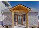 Charming stone home entrance with wooden beam entryway and covered porch at 20101 Spring Gulch Rd, Morrison, CO 80465