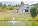 Two story home on a large lot with pond and fountain, mature trees, and grass at 20101 Spring Gulch Rd, Morrison, CO 80465