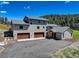 Home exterior boasts a three-car garage, stone accents, and a well-maintained driveway at 20101 Spring Gulch Rd, Morrison, CO 80465