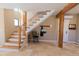 Inviting foyer featuring a staircase with wood treads and stone tile flooring and timber accents at 20101 Spring Gulch Rd, Morrison, CO 80465