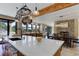 Open kitchen boasts a large island with white countertop, wooden cabinets, and a pot rack with a view at 20101 Spring Gulch Rd, Morrison, CO 80465