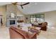 Open-concept living room with stone fireplace, travertine floors, and abundant natural light at 20101 Spring Gulch Rd, Morrison, CO 80465