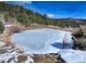 Picturesque pond covered with ice and some swans swimming on the pond; natural landscape setting at 20101 Spring Gulch Rd, Morrison, CO 80465