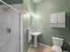 Bathroom featuring a pedestal sink, toilet, mirror, and white-tiled walk-in shower at 277 N Broadway # 403, Denver, CO 80203