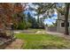Lush backyard featuring a spacious lawn, mature trees, garden beds, and a peaceful outdoor setting at 6302 S Ivy Ct, Centennial, CO 80111