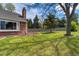 Large backyard with a well-kept lawn, mature trees, and a wooden fence providing privacy at 6302 S Ivy Ct, Centennial, CO 80111