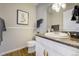 Traditional bathroom features white vanity with stone countertop, framed mirror, and linen storage at 6302 S Ivy Ct, Centennial, CO 80111