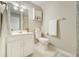 Bathroom featuring a white vanity, toilet, and a framed mirror with decorative light fixtures and a shower at 6302 S Ivy Ct, Centennial, CO 80111