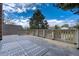 Spacious outdoor deck provides a serene spot with a patterned rug, wood railing, and treetop views at 6302 S Ivy Ct, Centennial, CO 80111