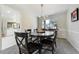 Bright dining room with a large window, stylish light fixture, and a dark wood table set for six at 6302 S Ivy Ct, Centennial, CO 80111