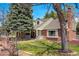 Beautiful brick home with lush green lawn, mature trees, and a charming front porch creating a welcoming facade at 6302 S Ivy Ct, Centennial, CO 80111