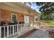 Inviting brick front porch with outdoor seating, decorative landscaping, and white railing at 6302 S Ivy Ct, Centennial, CO 80111