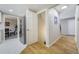 Hallway showcases updated stainless refrigerator, door to the basement, and access to dining area at 6302 S Ivy Ct, Centennial, CO 80111