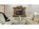 Cozy living room with a red brick fireplace, modern seating, and a glass coffee table for relaxed entertaining at 6302 S Ivy Ct, Centennial, CO 80111