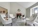 Bright living room with high ceilings, a fireplace, neutral color palette, and ample seating at 6302 S Ivy Ct, Centennial, CO 80111