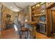 Home bar with stone feature wall and mini-fridge at 142 Outpost Ln, Evergreen, CO 80439