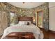 Stone-walled bedroom with hardwood floors and a comfy king bed at 142 Outpost Ln, Evergreen, CO 80439