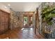 Grand foyer with stone walls, wood floors, and large windows creates a welcoming entrance at 142 Outpost Ln, Evergreen, CO 80439