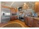 Open kitchen displaying stainless steel appliances, wood floors, cabinets and a stone accent wall at 142 Outpost Ln, Evergreen, CO 80439