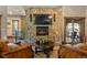 Living room with a stone fireplace, a modern TV and wooden floors with a round coffee table at 142 Outpost Ln, Evergreen, CO 80439
