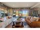 Inviting living room with stone walls, hardwood floors, and oversized windows for panoramic views at 142 Outpost Ln, Evergreen, CO 80439