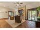 Living room with wooden floors, stone fireplace, ceiling fan, and access to the porch at 142 Outpost Ln, Evergreen, CO 80439