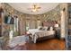 Cozy bedroom featuring stone walls, wood floors, and multiple windows for ample natural light at 142 Outpost Ln, Evergreen, CO 80439