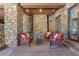 Stone patio with fireplace and comfortable seating, perfect for outdoor relaxation at 142 Outpost Ln, Evergreen, CO 80439