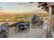 Outdoor patio with stone fireplace, mountain views, and dining set creates an inviting entertaining space at 142 Outpost Ln, Evergreen, CO 80439