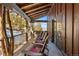 Covered porch with log beams, stone accents, and outdoor seating with a mountain view at 142 Outpost Ln, Evergreen, CO 80439