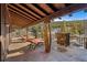 Open porch overlooking a forest with stone pillars and two lounge chairs for relaxing at 142 Outpost Ln, Evergreen, CO 80439